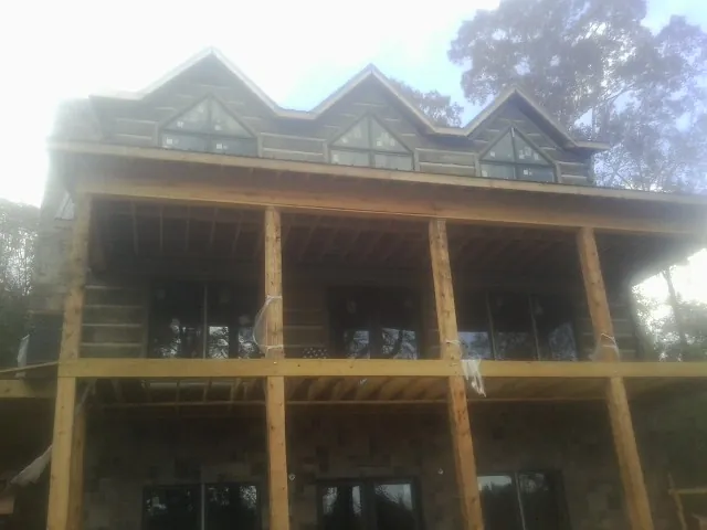 Dormers and porch framing on a large log home under construction — Roof Coating work by our crew in Hagerstown