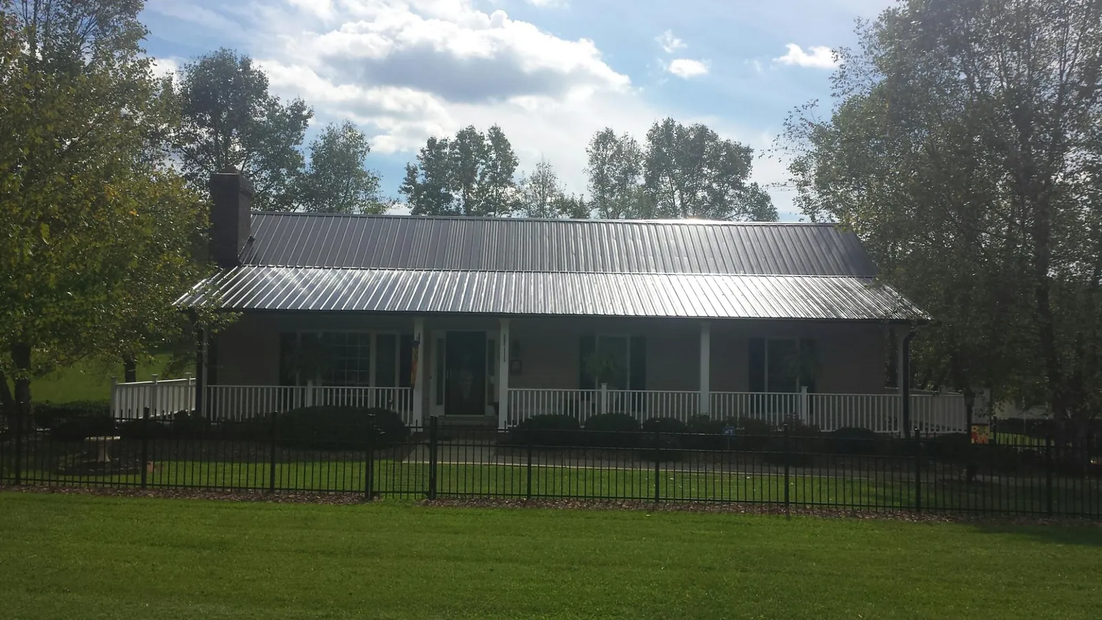 Gray metal roof on a brick ranch with a full width front porch — Gutter Guard Installation work by our crew in Hagerstown